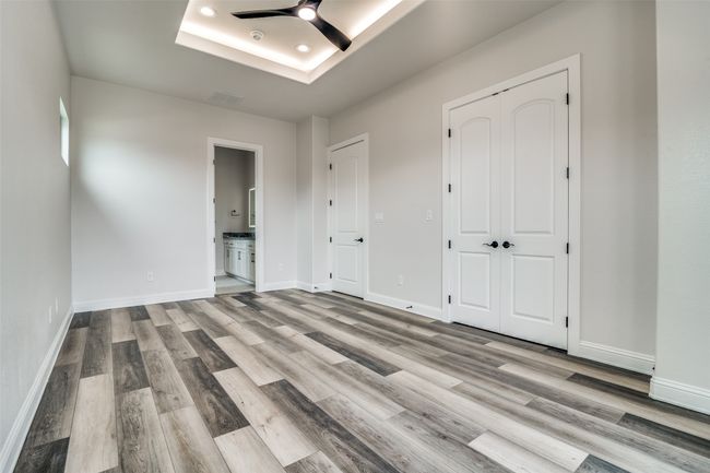 Spare room with a raised ceiling, ceiling fan, and hardwood / wood-style floors | Image 19