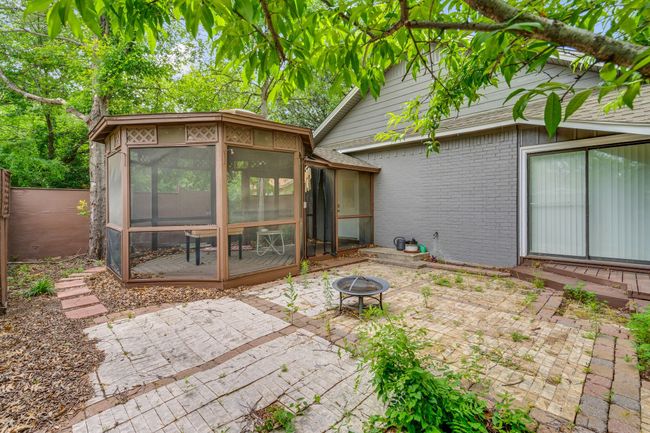 Back of house with a sunroom, a fire pit, a patio area, and brick siding | Image 28