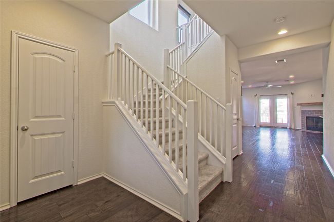 Stairs featuring wood-type flooring, ceiling fan, a fireplace, and recessed lighting | Image 6