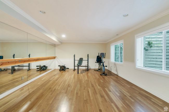 Workout area featuring light wood-style flooring, baseboards, crown molding, and recessed lighting | Image 20