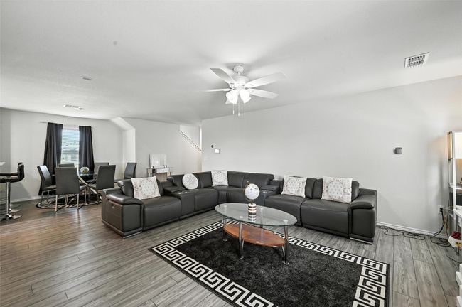 Living area featuring ceiling fan and wood finished floors | Image 5