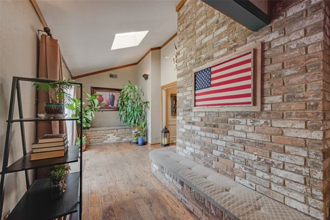Hallway with a skylight, vaulted ceiling, crown molding, and hardwood / wood-style floors | Image 13