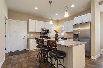 Recessed lighting, combined with stylish pendant fixtures over the island, brightens the space, creating a warm and inviting atmosphere. | Image 3