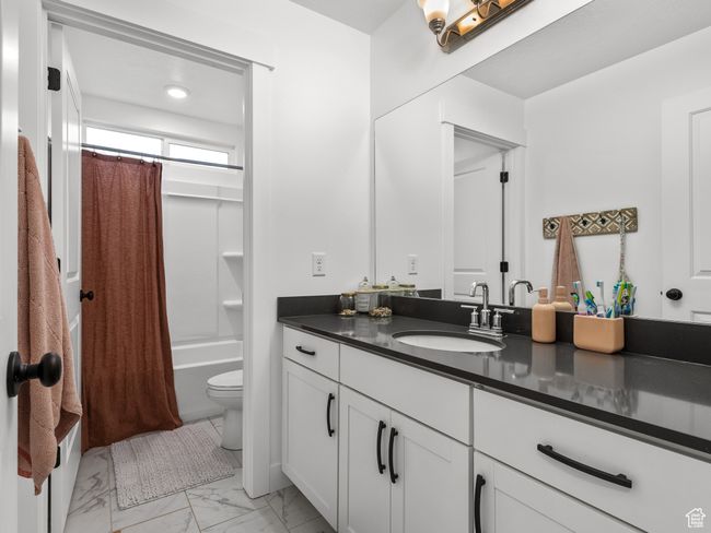 Full bath featuring vanity, shower / bath combo, and marble finish flooring | Image 16