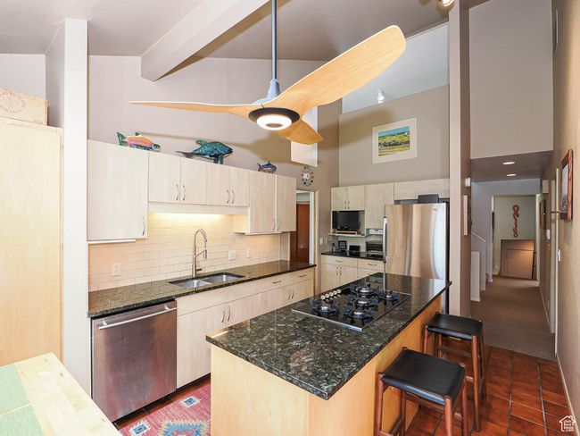 Kitchen featuring appliances with stainless steel finishes, backsplash, dark stone counters, and a towering ceiling | Image 24