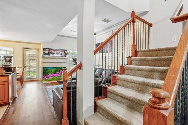 Stairs with wood finished floors, a fireplace, and ceiling fan | Image 17