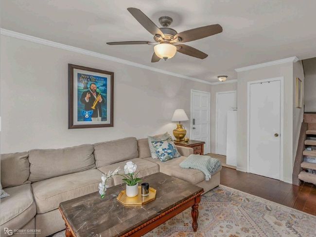 Living room with wood-type flooring, crown molding, and a ceiling fan | Image 7
