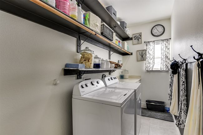 Laundry room with washer and dryer and light tile patterned flooring | Image 23