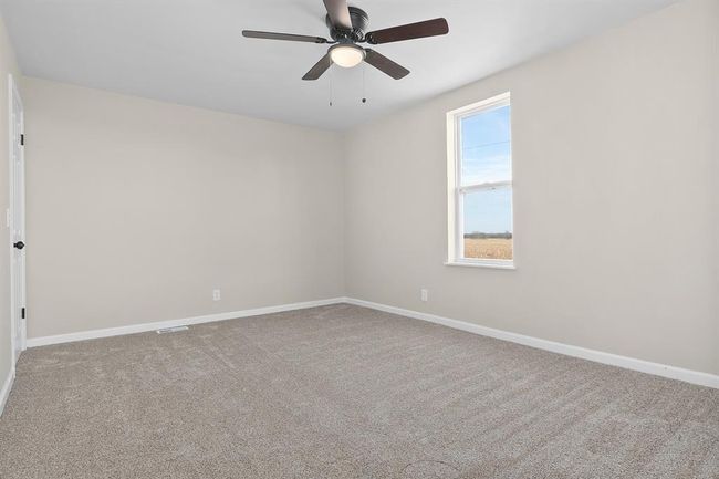 Carpeted spare room featuring a ceiling fan and baseboards | Image 14