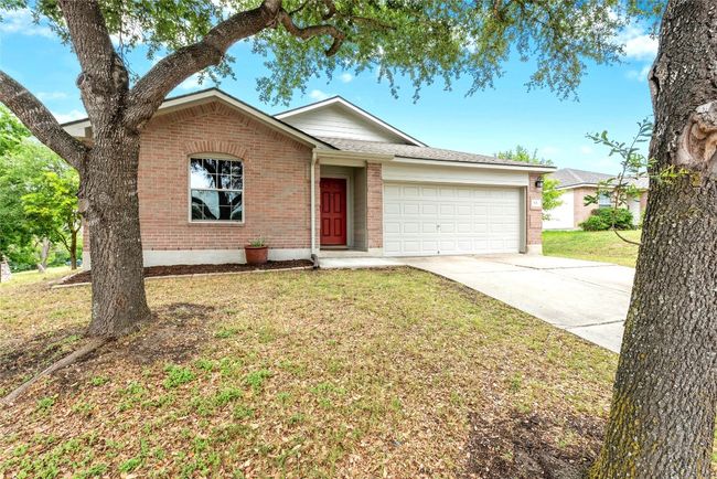 Ranch-style house featuring brick siding, an attached garage, concrete driveway, and a front yard | Image 28