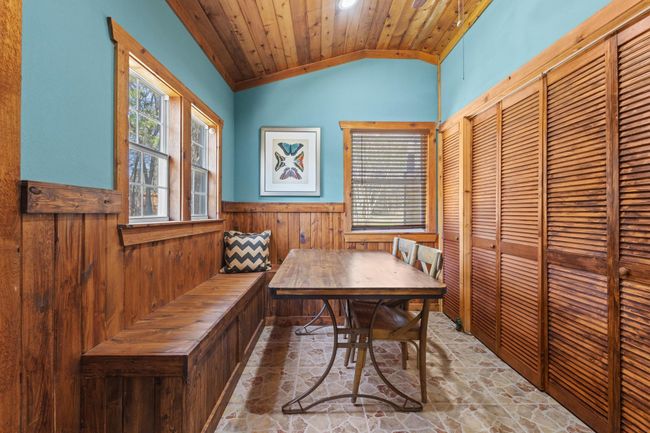 Dining space featuring a wainscoted wall, vaulted ceiling, wooden ceiling, wooden walls, and stone finish floor | Image 28