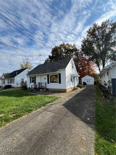 View of front of home featuring an outdoor structure, a garage, and a front lawn | Image 2