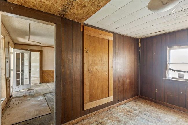 Spare room featuring wood walls | Image 15