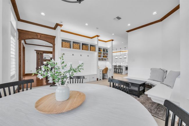Light and bright breakfast room with built-in mudroom shelving, seating area with bench and student desk. | Image 15