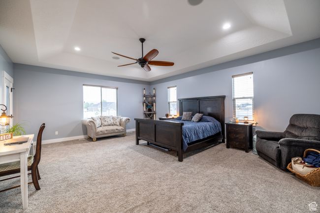 Bedroom with a tray ceiling, recessed lighting, light colored carpet, and ceiling fan | Image 26