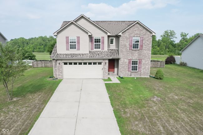 traditional-style house with brick siding, a garage, driveway, and roof with shingles | Image 30