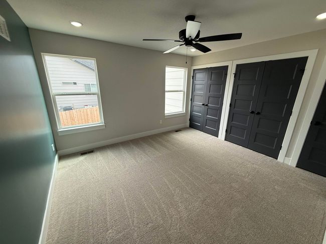 Unfurnished bedroom featuring two closets, carpet floors, baseboards, multiple windows, and recessed lighting | Image 8