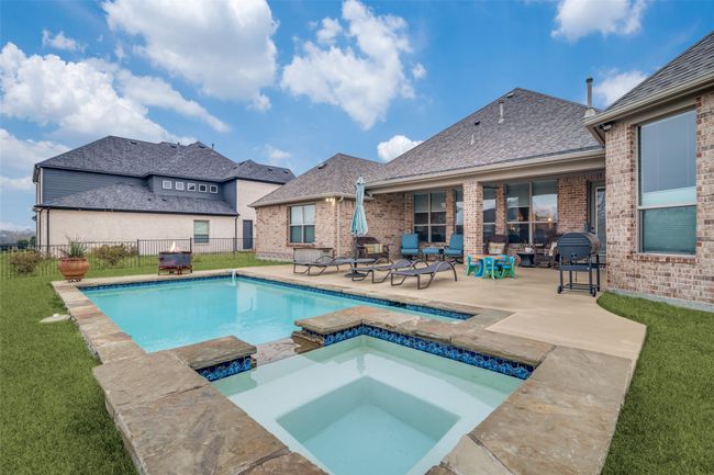 Serene pool and spa are heated and surrounded by wrought iron fencing. | Image 27