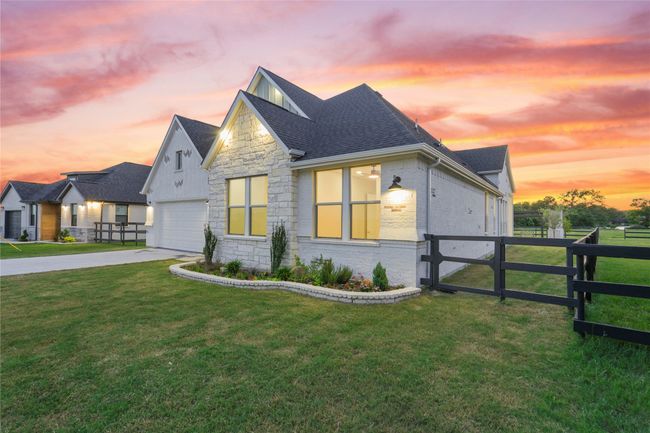 View of front of home featuring a shingled roof, brick siding, stone siding, and driveway | Image 31