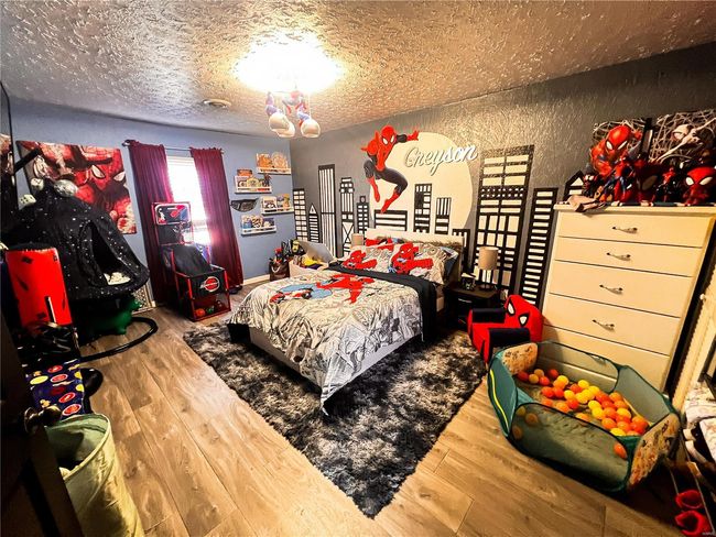 Bedroom featuring a textured ceiling and wood finished floors | Image 17