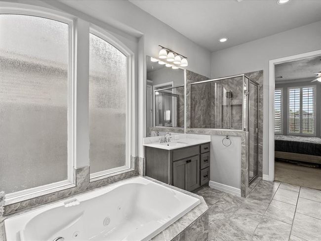 The primary en-suite bath features dual vanities, a soaking tub, walk-in shower and a large walk-in closet | Image 21