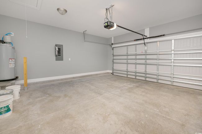 Garage featuring a garage door opener, electric water heater, and electric panel | Image 14