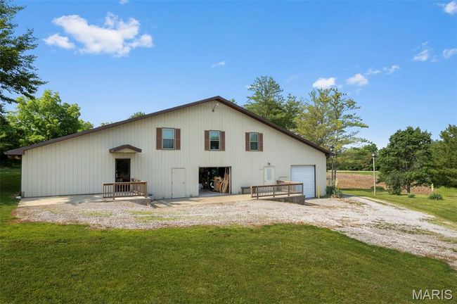 Rear view of house featuring a lawn, an outbuilding, and a garage | Image 13