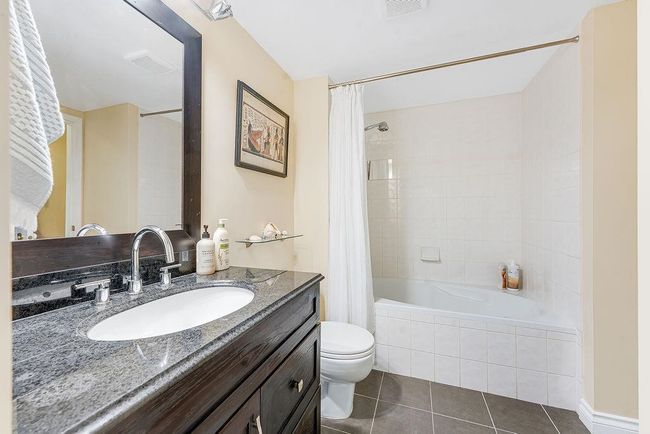 Bathroom with tile patterned floors, vanity, toilet, and tiled shower / bath | Image 6