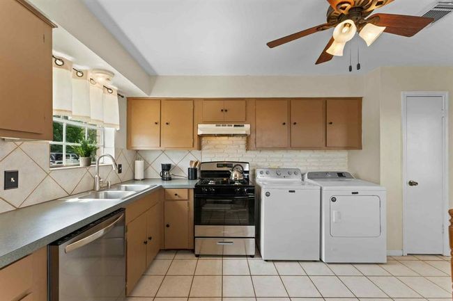 Convenient kitchen layout with in-home washer and dryer tucked nearby—combining function and comfort all in one space. | Image 13