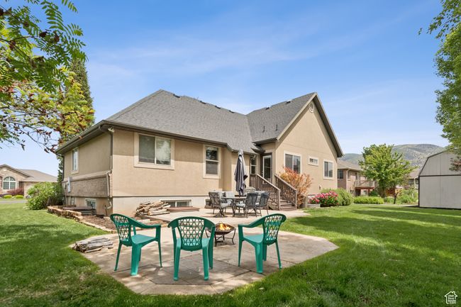 Rear view of property with a lawn, stucco siding, and a patio area | Image 36