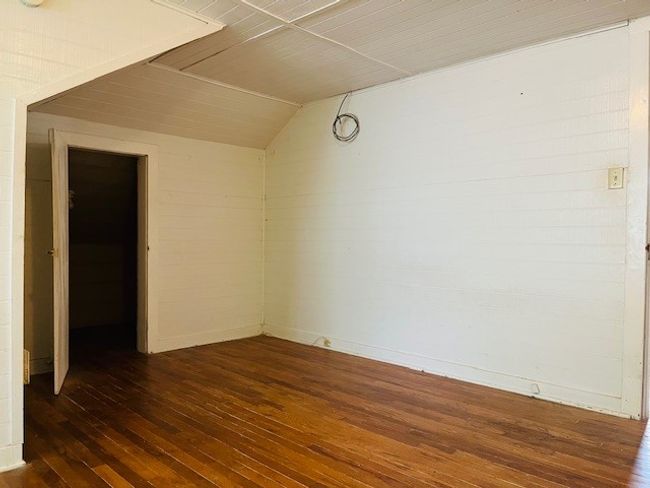 Empty room featuring dark wood-style floors and vaulted ceiling | Image 28