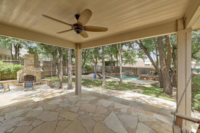 The extended covered patio provides plenty of space for outdoor dining or lounging, offering shelter from the elements while you enjoy the serene backyard views in comfort | Image 35