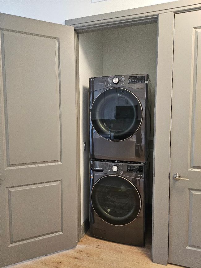 Washroom featuring stacked washer / dryer, laundry area, and light wood-style flooring | Image 21