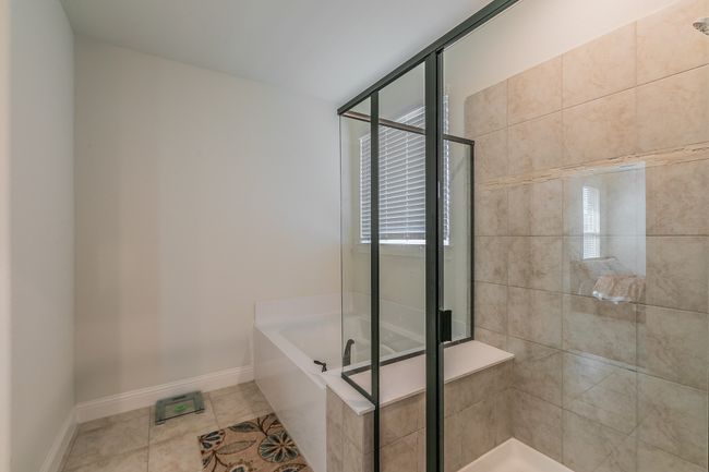 Bathroom with tile patterned floors, a garden tub, baseboards, and a shower stall | Image 33