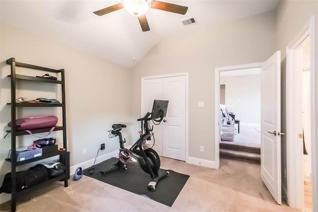 One of the three upstairs secondary bedrooms. This one is located a few steps off of the gameroom and features an ensuite bathroom. All rooms have a ceiling fan. | Image 26