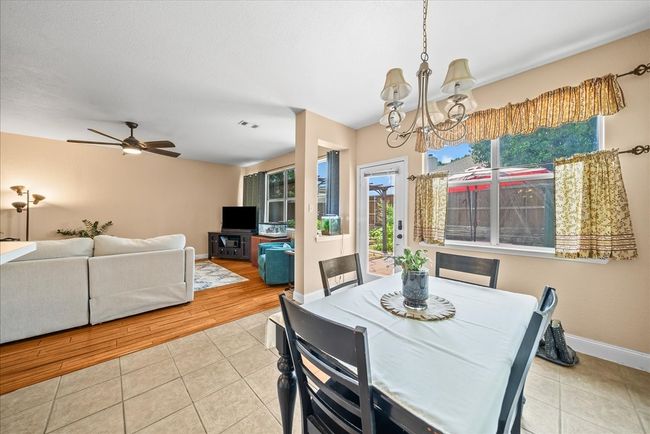 Dining space with a chandelier, tile patterned flooring, baseboards, and ceiling fan | Image 20
