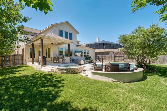 Rear view of property with an outdoor hot tub, a fenced backyard, a patio, an outdoor hangout area, and ceiling fan | Image 32