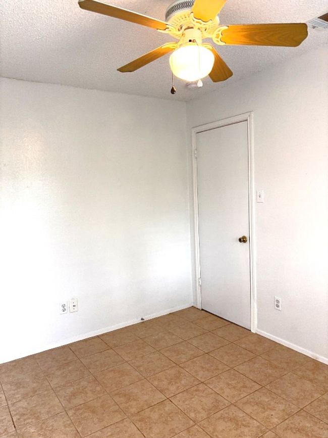 Unfurnished room with ceiling fan, light tile patterned floors, and a textured ceiling | Image 12