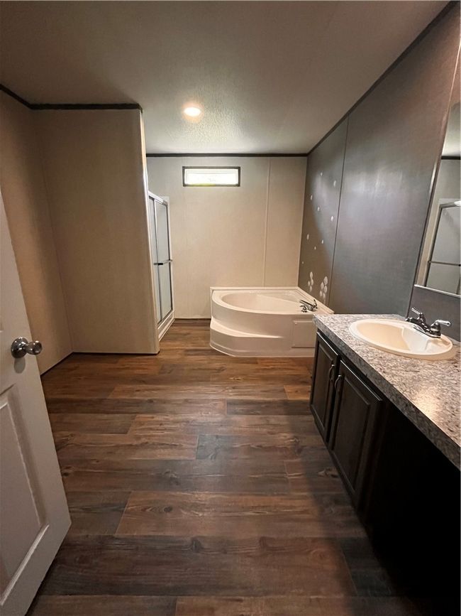 Full bathroom with vanity, a bath, a stall shower, and wood finished floors | Image 8