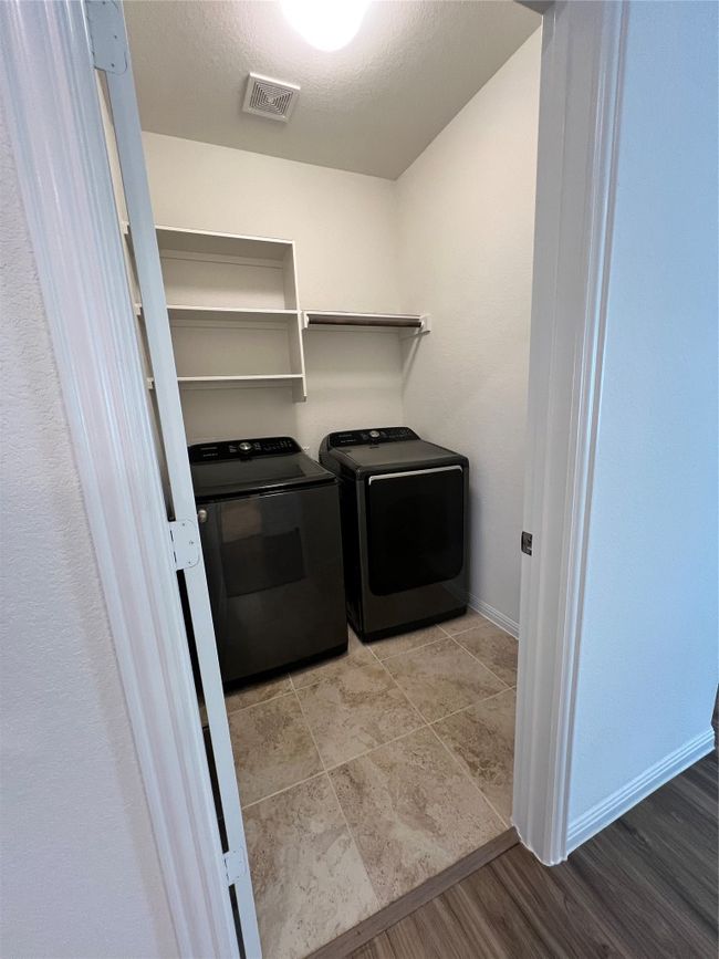 Washroom with light wood-style floors, independent washer and dryer, and a textured ceiling | Image 21