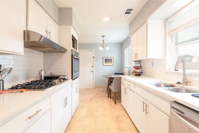 Kitchen features stainless steel appliances, 6-burner gas stove, under cabinet range hood, double sink and plenty of cabinets, eat-in kitchen | Image 17