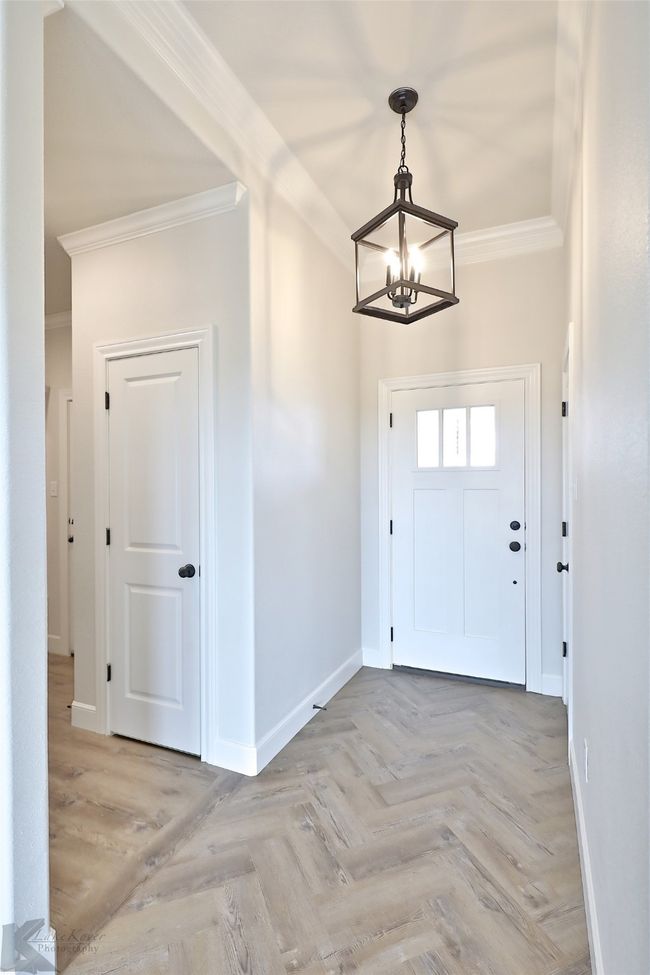 Foyer entrance featuring ornamental molding and a chandelier | Image 32