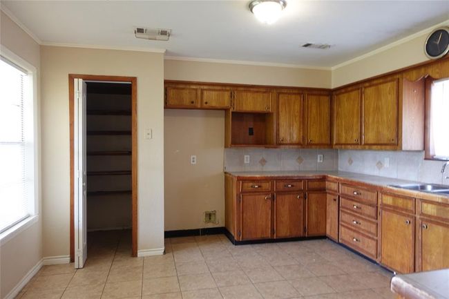 Spacious kitchen with ample cabinets and a convenient walk-in pantry, perfectly viewed from the dining area. | Image 7