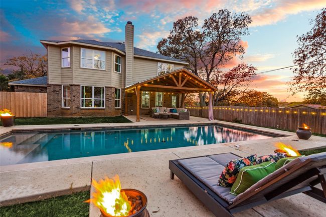 View of swimming pool with an outdoor living space with a fire pit, a fenced backyard, and a patio | Image 23