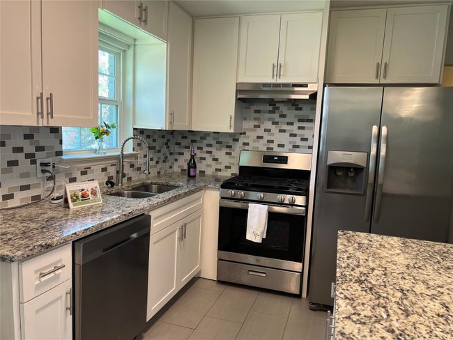 Updated kitchen with granite counter tops, stainless steel furniture, tile floor, fridge included | Image 7