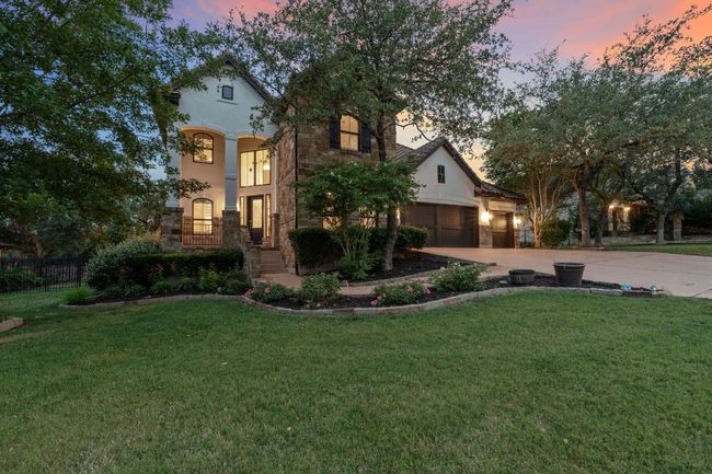 Mediterranean / spanish-style home featuring driveway, stucco siding, an attached garage, and stone siding | Image 9