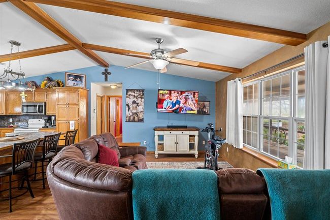 Living room featuring lofted ceiling with beams, ceiling fan, and wood finished floors | Image 18