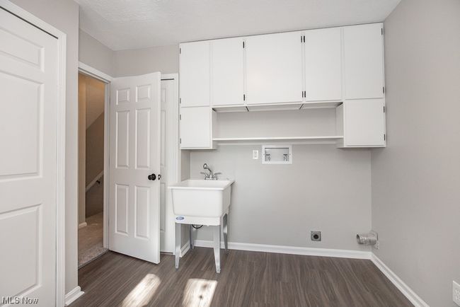 Clothes washing area featuring hookup for an electric dryer, cabinets, dark hardwood / wood-style flooring, and hookup for a washing machine | Image 20