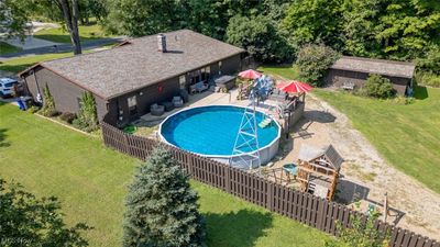 View of swimming pool with a 28x16 shed, large deck and additional drive | Image 2