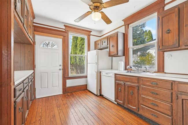 Kitchen featuring dishwasher, a sink, light countertops, ceiling fan, and light wood-style floors | Image 11
